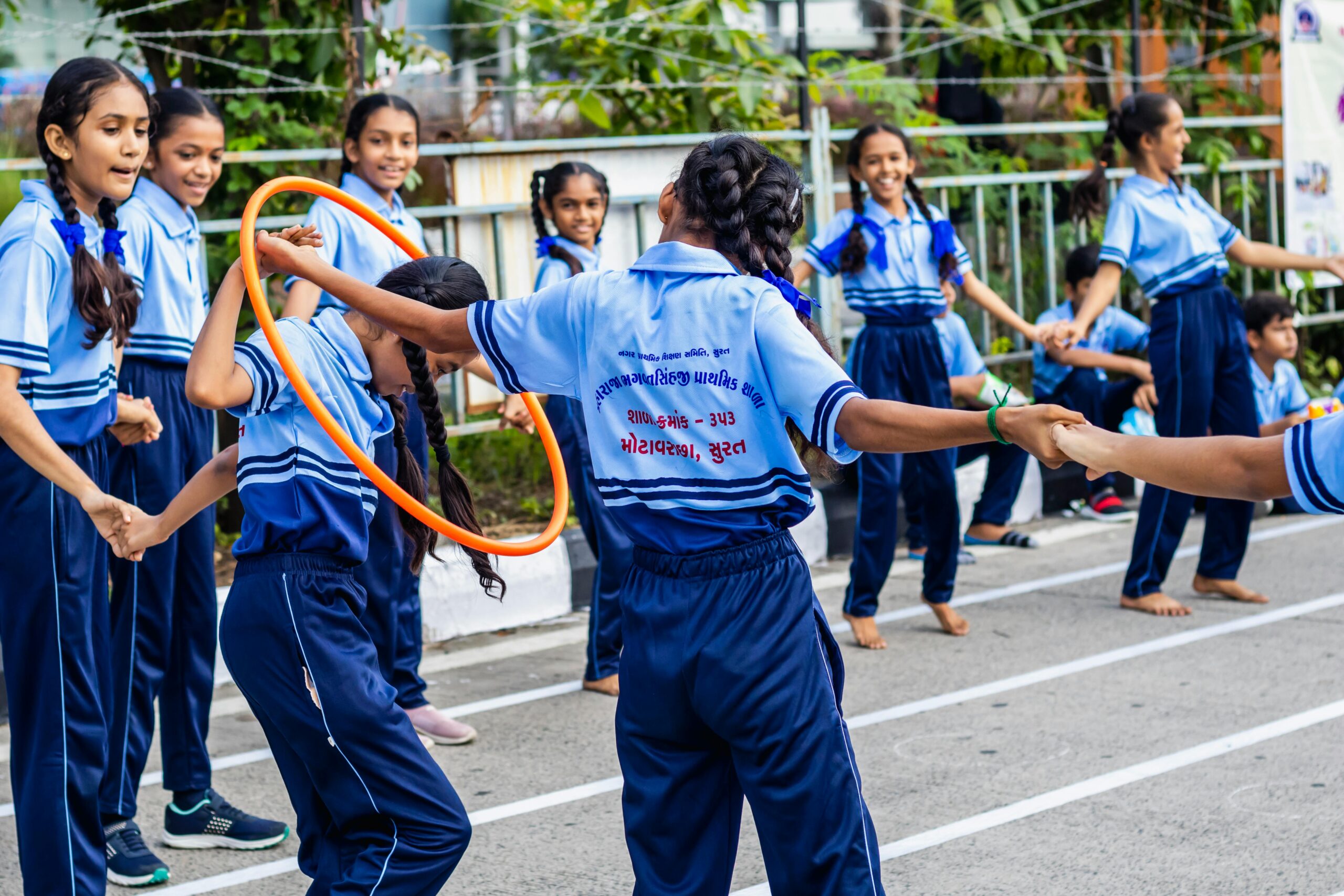 Schools & Educational Institutions Group of schoolchildren enjoying outdoor games with hula hoops at a school event in Surat, India.