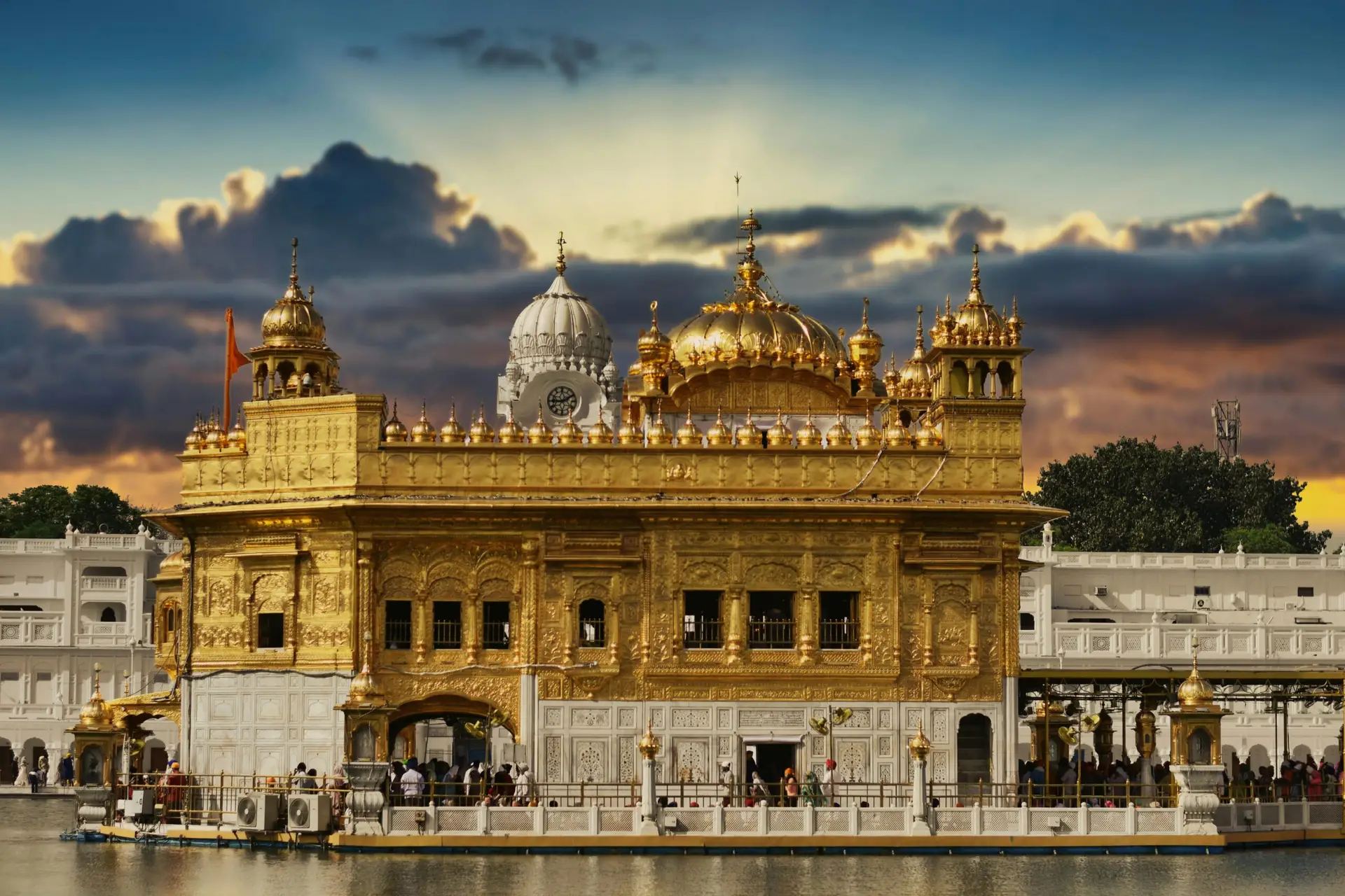 Individuals & Families Stunning view of the Golden Temple in Amritsar, India, with a vibrant sunset sky.