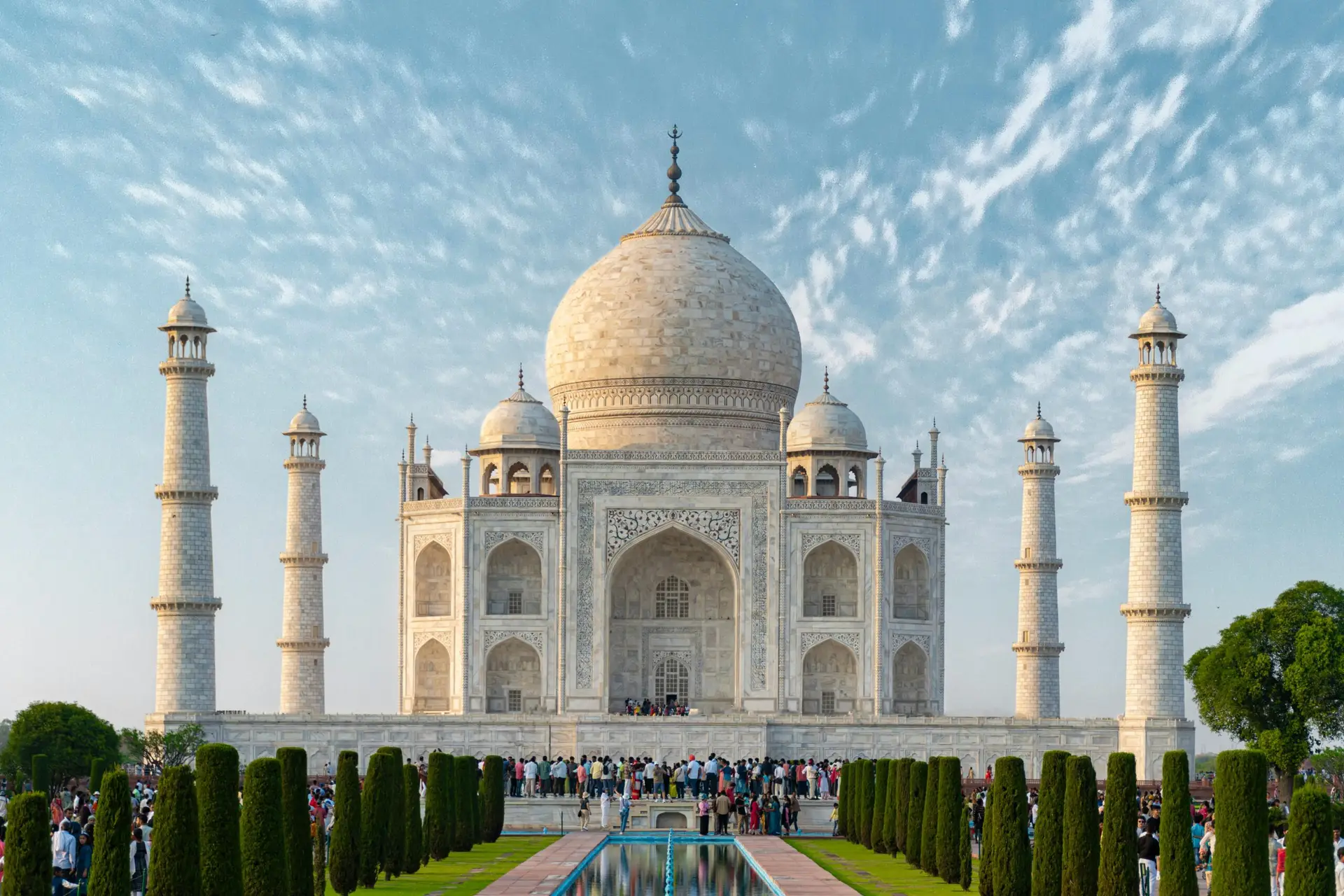 Individuals & Families Explore the iconic Taj Mahal, a UNESCO World Heritage Site in Agra, India, captured under a bright blue sky.