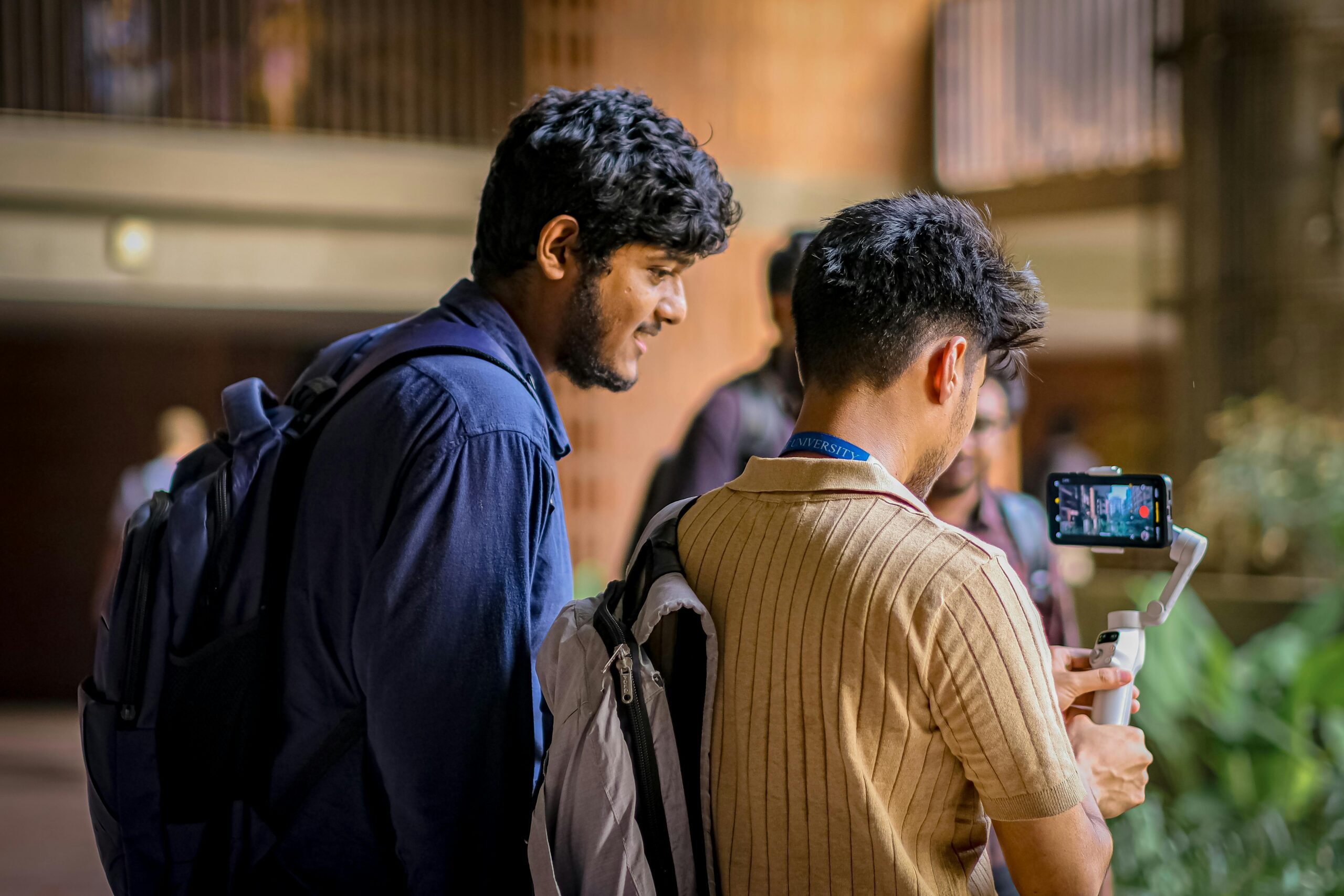 Schools & Educational Institutions Two students capturing video content using a mobile stabilizer indoors at a university.