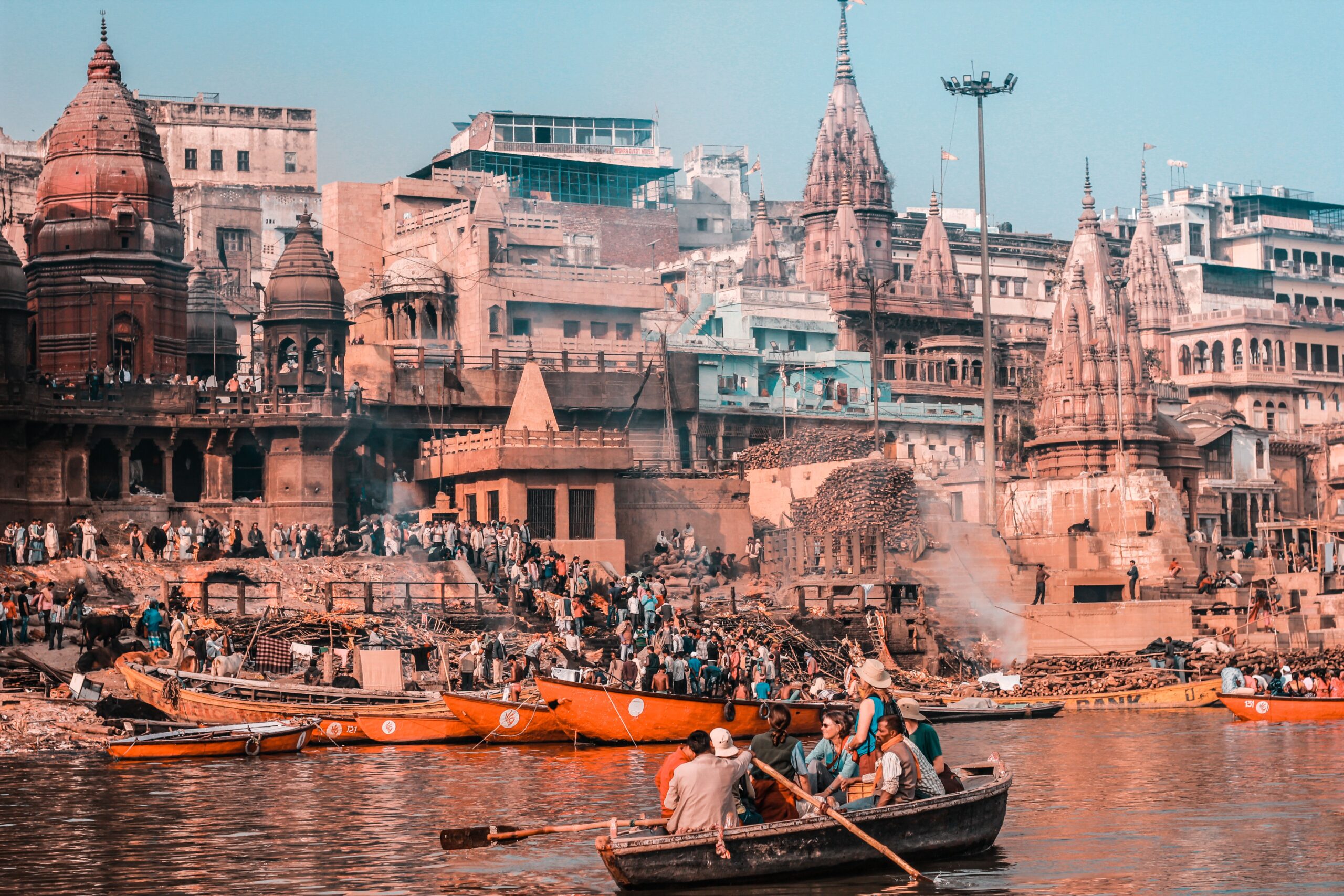 Individuals & Families Bustling scene of Varanasi's riverfront with temples and boats on the Ganges River, capturing spirituality.